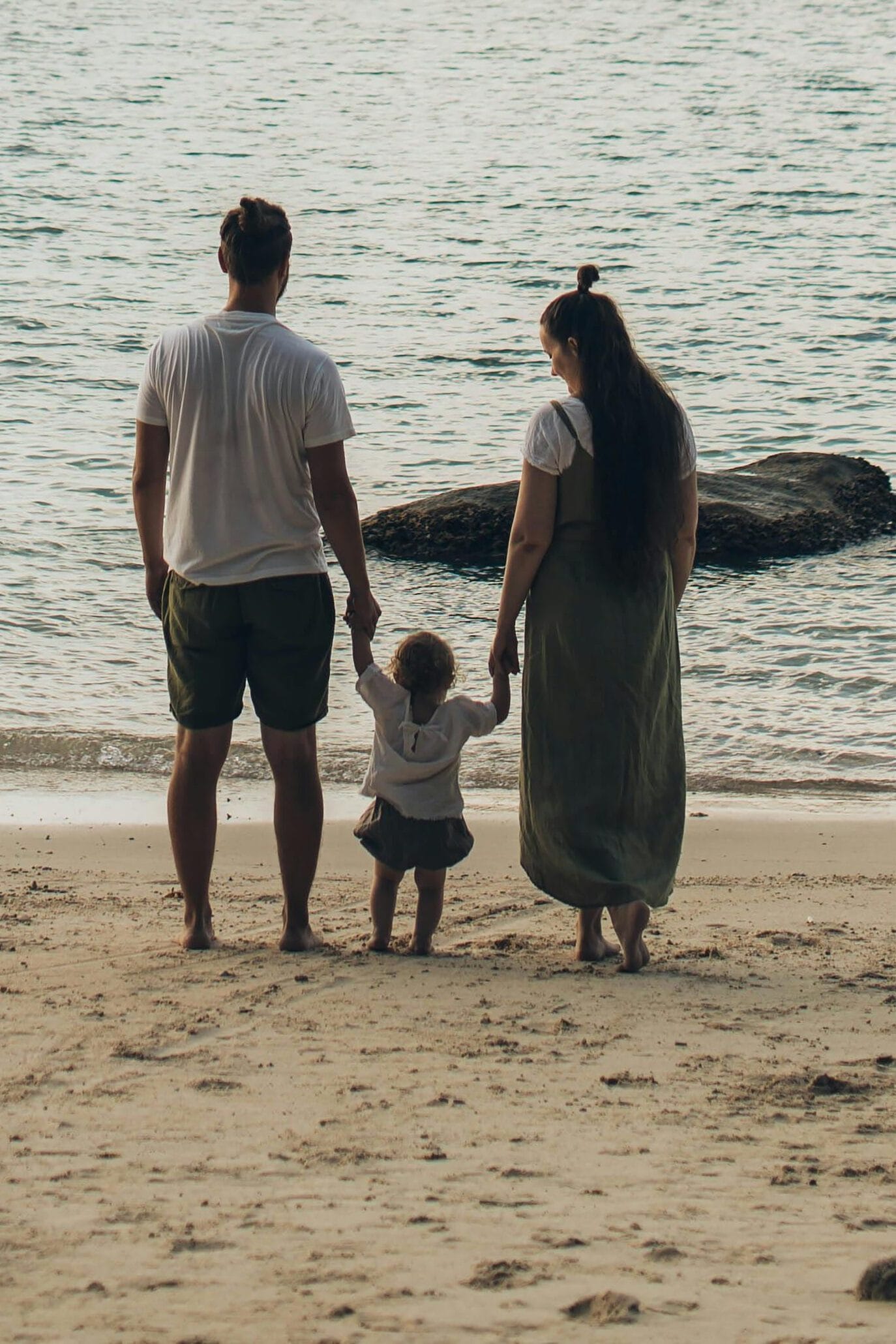 A family enjoys a tranquil day at the beach, highlighting togetherness and love.